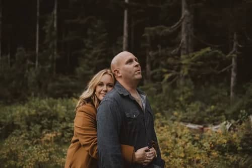 Couple posing in front of woods