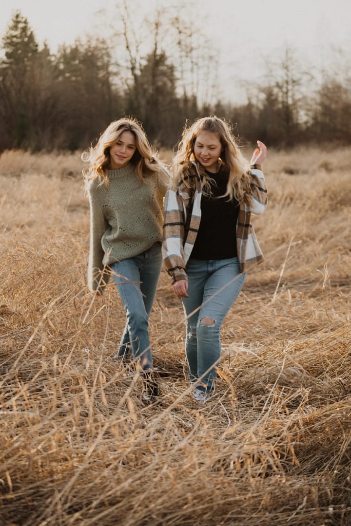 Two teenage girls walking through a field